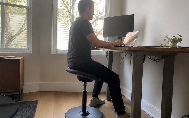 Ergonomischer Bürohocker am Stehschreibtisch